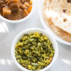 shepu bhaji served in a white bowl with a bowl of vegetable curry and a plate of chapattis kept on the top left and right side and text layovers.