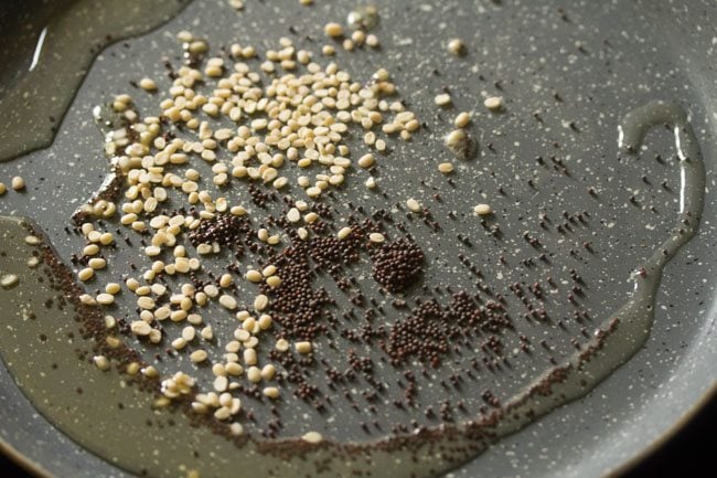 mustard seeds and black gram added to hot oil in pan. 