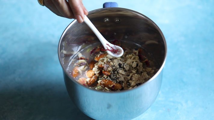 adding saffron in grinder jar for making thandai paste. 