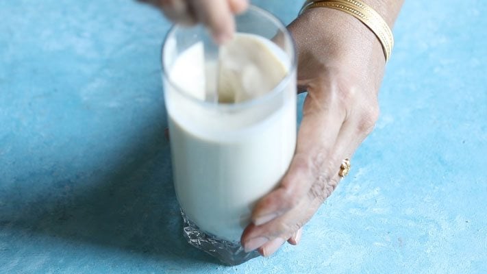 mixing milk with thandai paste. 