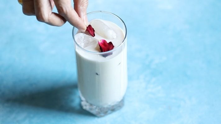 garnishing thandai with fresh rose petals. 