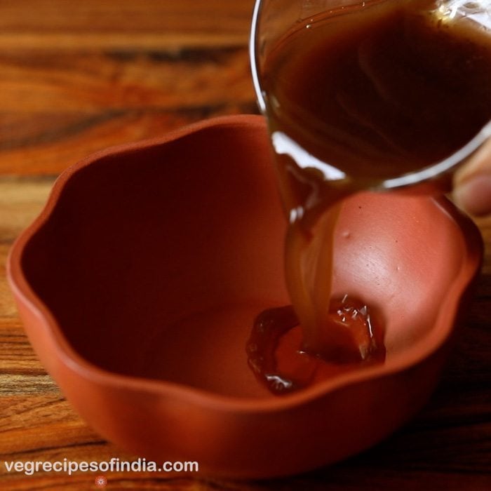 adding tamarind pulp to a bowl. 