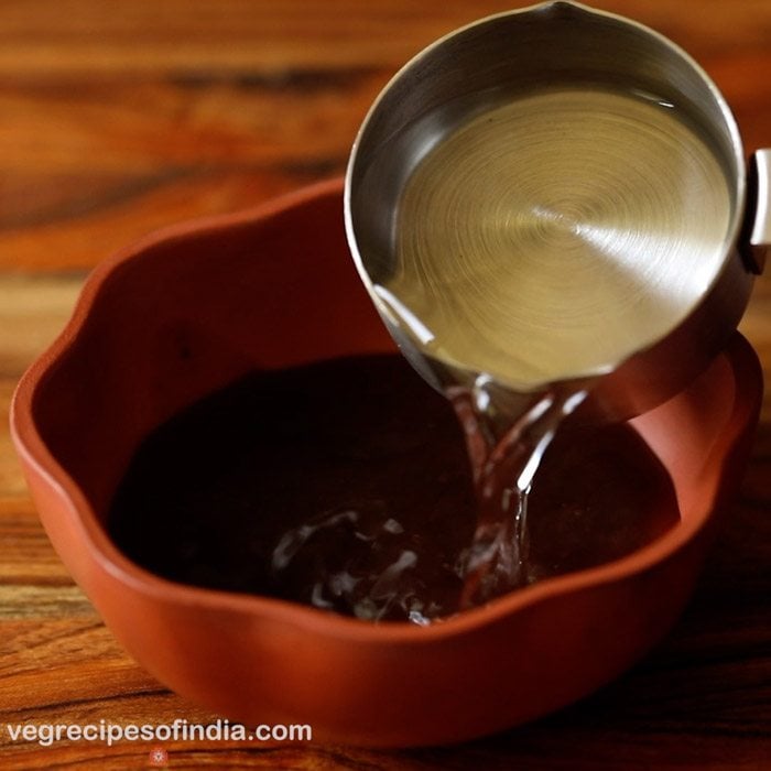 adding water to tamarind pulp.