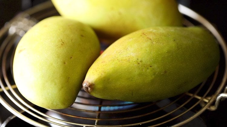 roasting green mangoes on stovetop flame