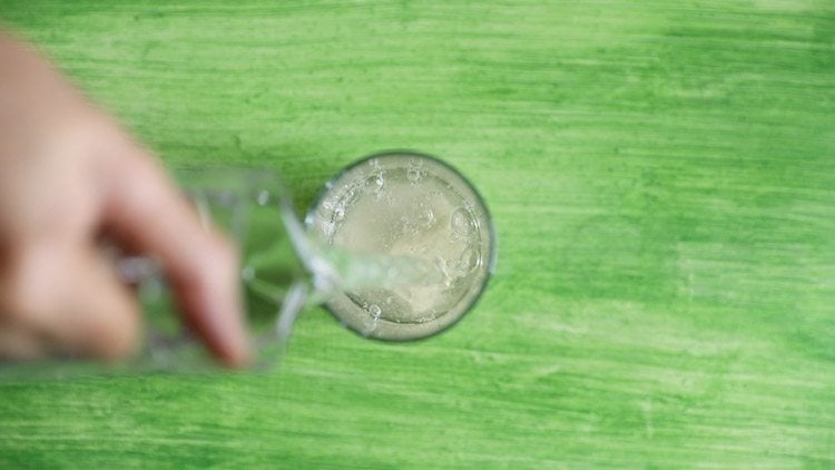 water being added to the glass containing aam panna syrup