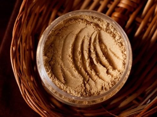 amchur powder in a jar on oval bamboo tray.