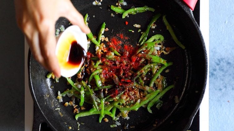 hand pouring in soy sauce