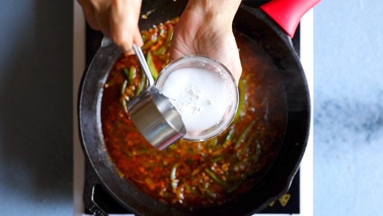 water being poured into bowl with cornstarch for making slurry