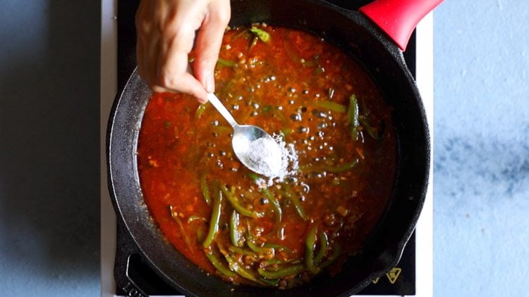 seasoning the chilli paneer sauce with salt after cooking