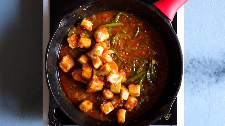 fried paneer cubes added to pan with chilli sauce