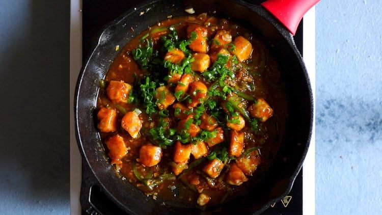 green onions added to chilli paneer in pan