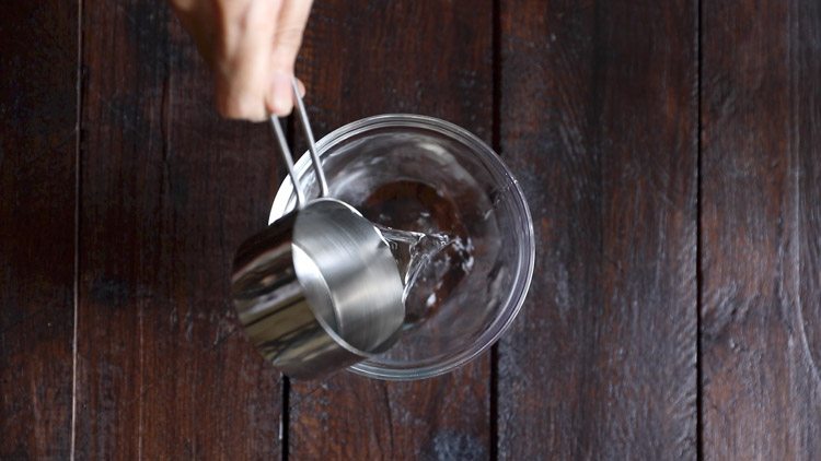 adding warm water in a small bowl for chocolate milkshake recipe. 