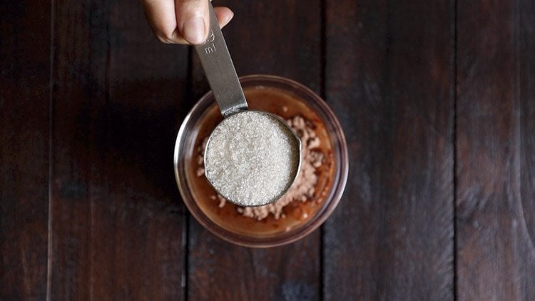 adding sugar to bowl for chocolate milkshake recipe. 