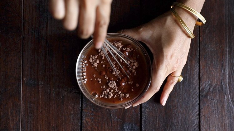 mixing coco powder and sugar in the water for chocolate milkshake recipe. 