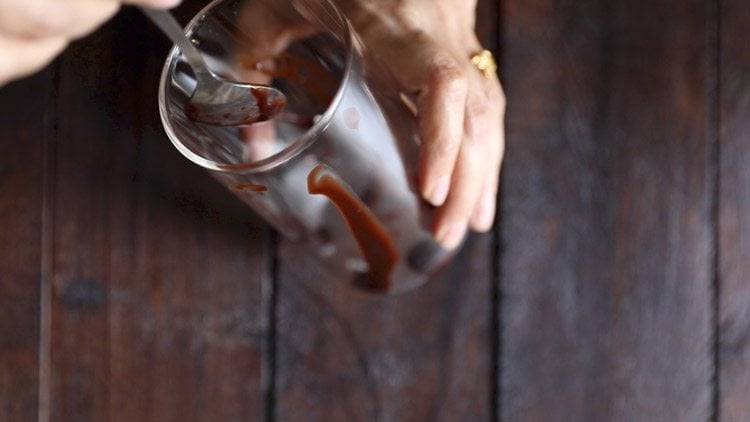 drizzling chocolate syrup on the sides of glasses. 