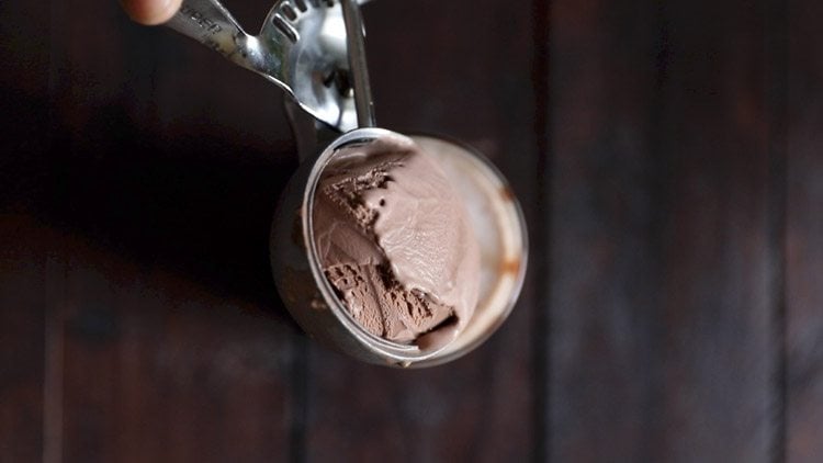 adding a scoop of chocolate ice cream on the milkshake. 