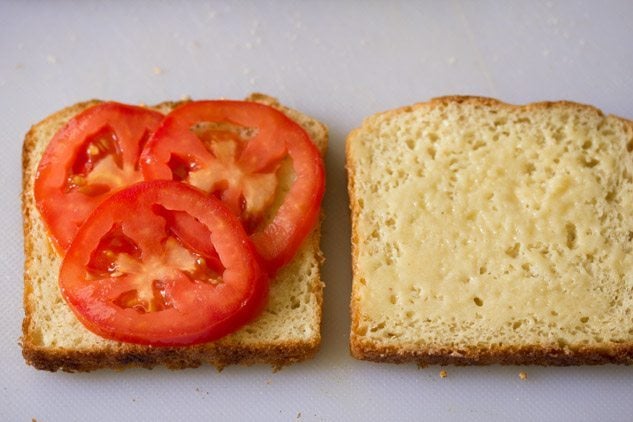 tomato slices placed on one buttered bread slice. 
