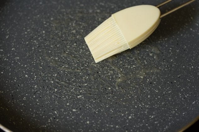 brushing butter on a pan. 