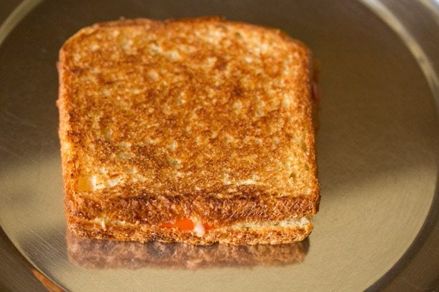 grilled tomato cheese sandwich on a plate. 