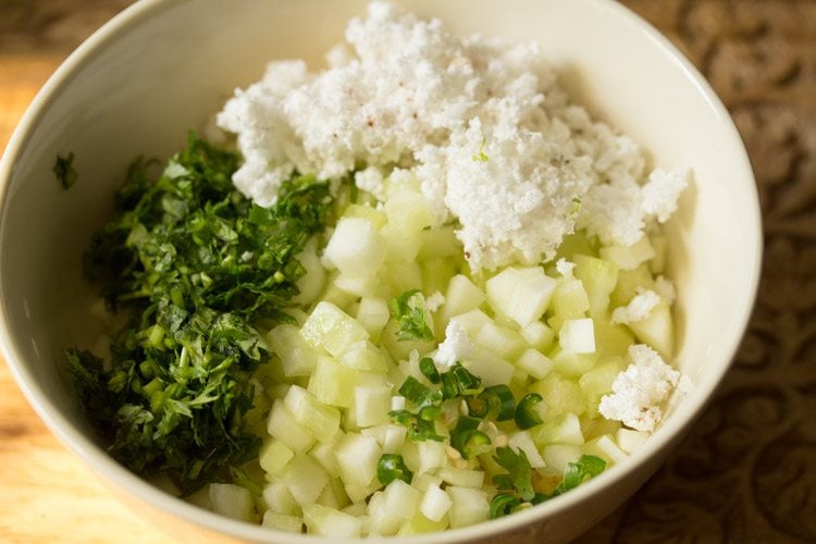 finely chopped cucumber, fresh grated coconut, chopped coriander leaves and chopped green chili added to the moong dal in the bowl. 