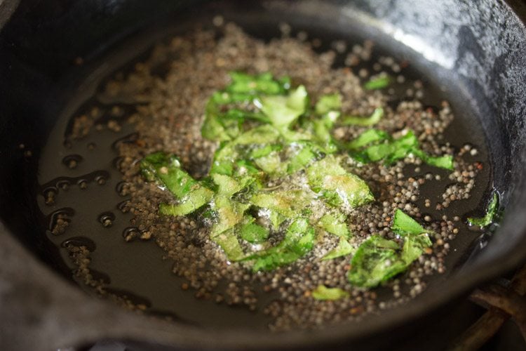 curry leaves and asafoetida added to crackling mustard seeds in hot oil. 