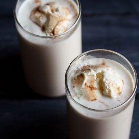 jigarthanda topped with vanilla ice cream in 2 serving glasses with text layovers.