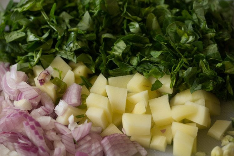 chopped methi leaves, chopped onions and chopped potatoes. 