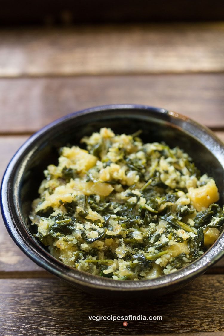 methi bhaji served in a  ceramic bowl with text layover. 