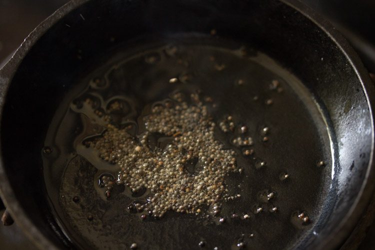 asafoetida added to hot oil in pan. 