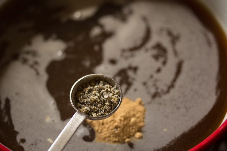 adding cardamom powder to jaggery solution. 