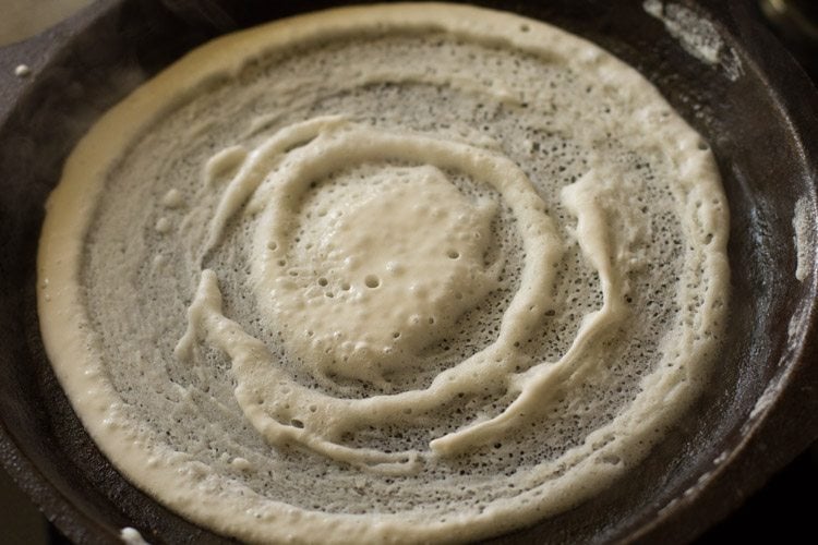 batter spread into a round dosa on hot tawa. 