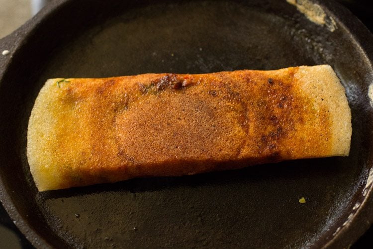 schezwan dosa turned over on the tawa. 