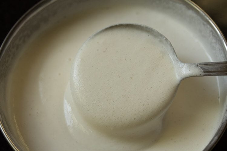 stirring dosa batter in a bowl. 