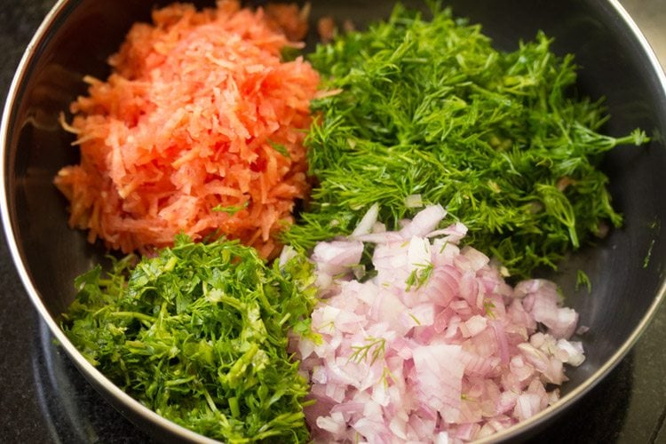 dill leaves, carrots, onions and coriander in a pan