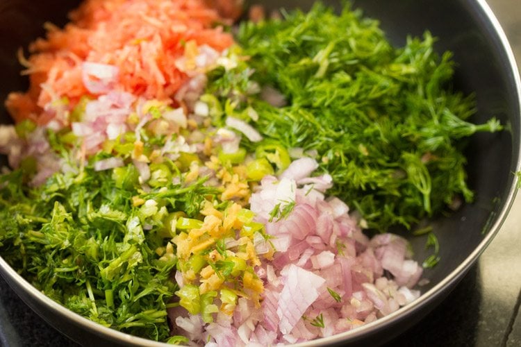 dill leaves, carrots, onions, ginger, green chilies and coriander in a pan