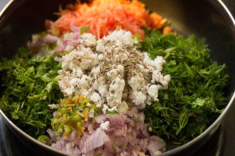 coconut, cumin seeds, dill leaves, carrots, onions, ginger, green chilies and coriander in a pan