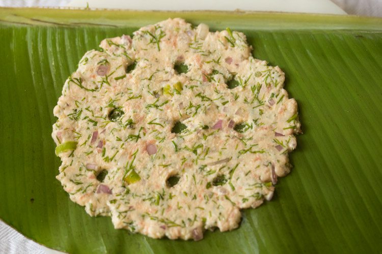 rolled akki roti with holes on plantain leaf