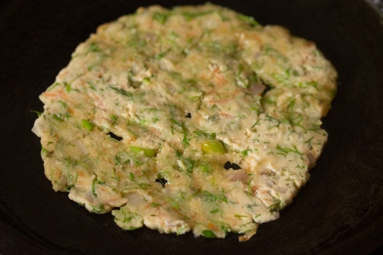 adding oil to akki roti on skillet