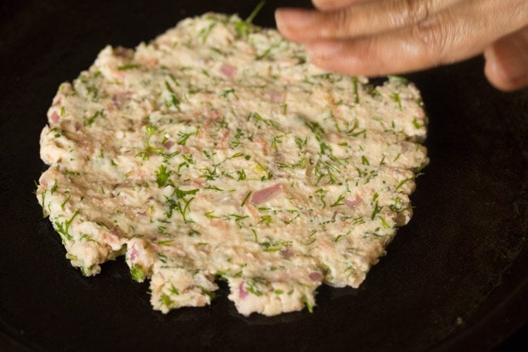 portion of the dough and flattened on the tawa