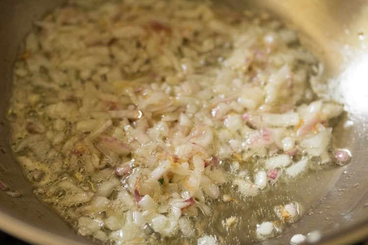 Sautéing onions till translucent for making aloo palak ki sabji. 