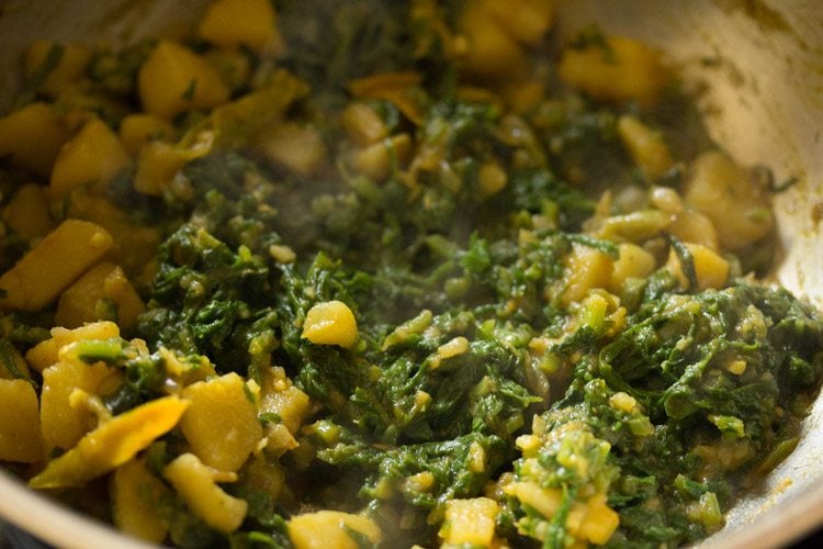 spinach leaves cooked and wilted in the pan.