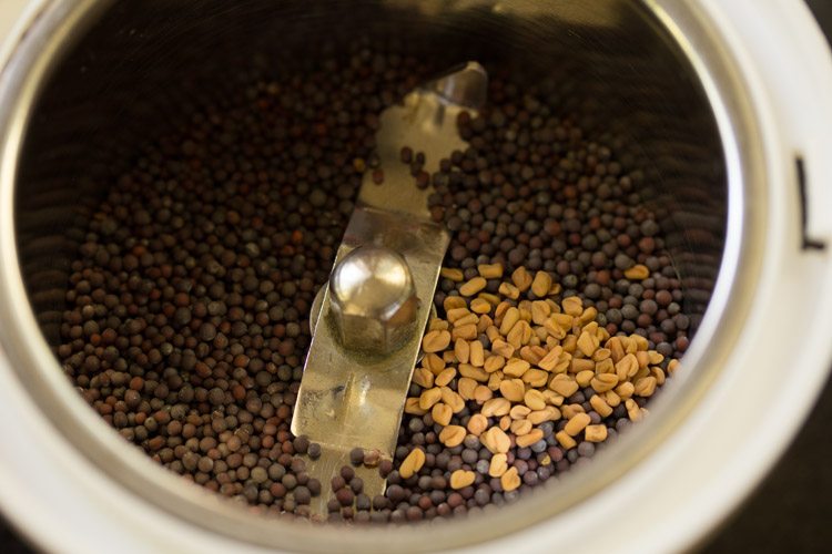 mustard seeds and fenugreek seeds added in a grinder. 