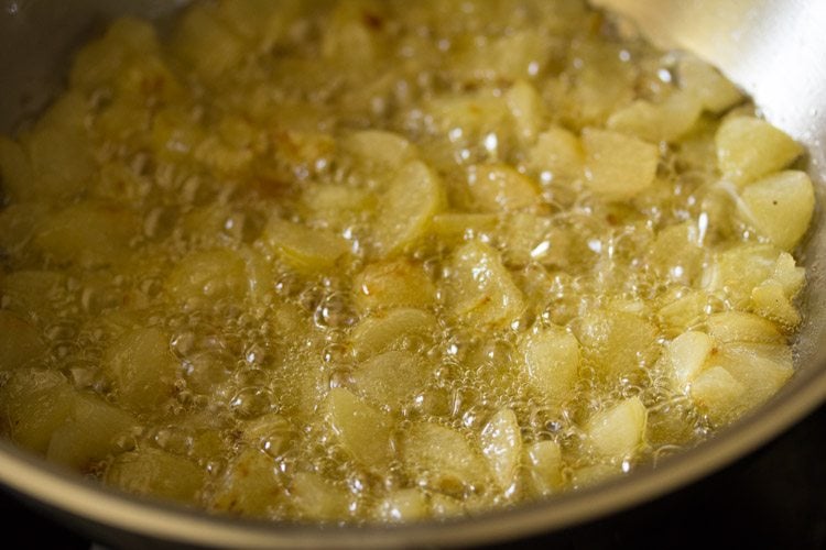 cooking the amla pieces in the pan to make amla ka achar.