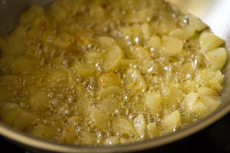 cooking the amla pieces in the pan to make amla ka achar. 