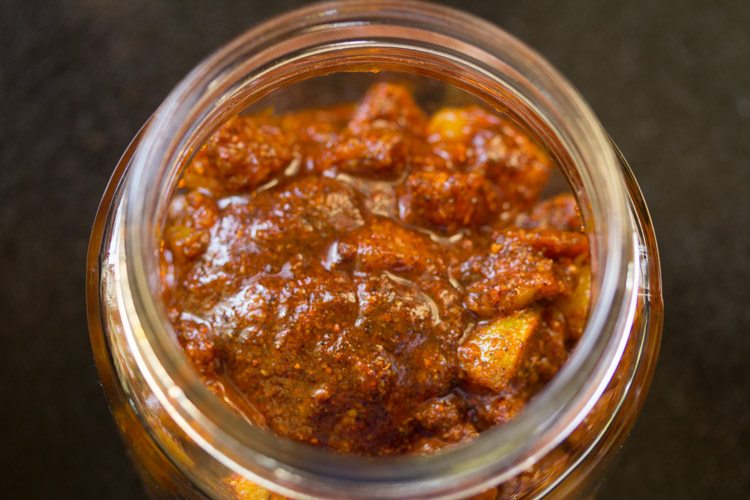 amla pickle or amla achar spooned in a sterilized glass jar. 