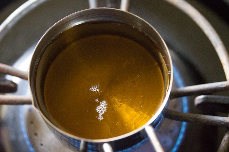 calentar aceite de sésamo para templar el pepinillo amla. 