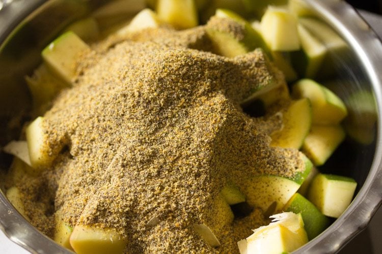 adding mustard powder to the mango pieces 