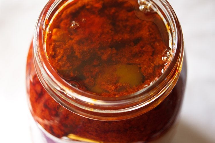 adding more sesame oil on the avakai pickle in the glass jar 