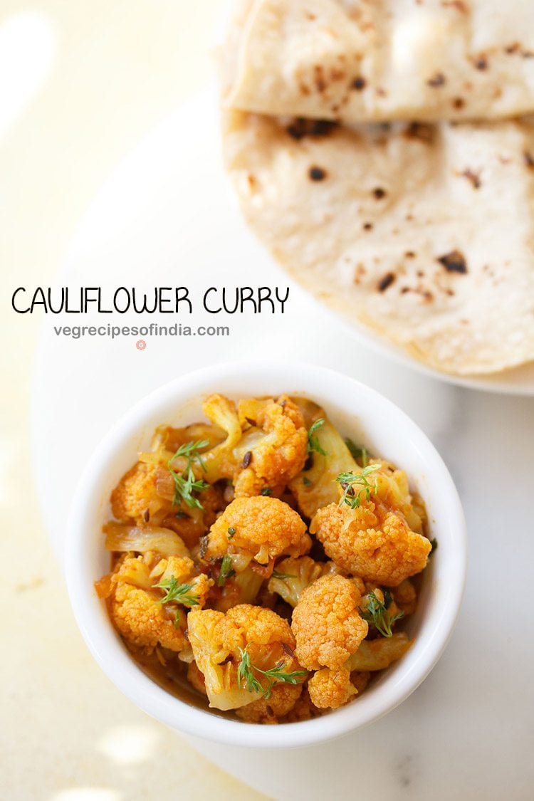 cauliflower curry garnished with coriander leaves and served in a white bowl with a plate of chapattis kept on the top right side and text layovers.