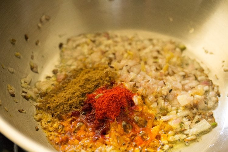spice powders added to pan. 